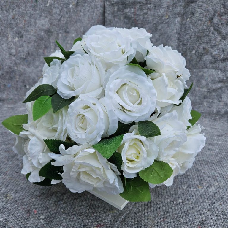 Een boeket witte rozen met groene bladeren.